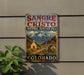 A vintage-style metal sign for the Sangre de Cristo National Heritage Area in Colorado, featuring a mountain landscape and a church.
