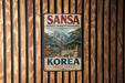 A vintage metal sign for the Buddhist Mountain Monasteries in South Korea, featuring a scenic mountain landscape with traditional Korean buildings.