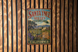 A vintage metal sign for Santa Ynez Valley, California, featuring a scenic landscape with vineyards and mountains.