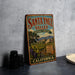 A vintage metal sign for Santa Ynez Valley, featuring a scenic landscape with vineyards and mountains, is displayed on a gray countertop.