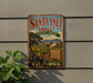 A vintage-style metal sign for Santa Ynez Valley, California, featuring a scenic landscape with vineyards and mountains.