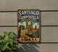 A vintage metal sign for Santiagó de Compostela, a city in Spain, featuring an illustration of the city's landmarks and a directional sign.