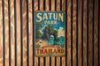A vintage metal sign for Satun Park in Thailand, featuring a tropical landscape with a rock formation and palm trees.