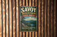 A vintage metal sign for Savoy Mountain State Forest in Massachusetts, featuring a scenic landscape with pine trees, a lake, and mountains.