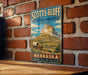 A vintage-style metal sign for the National Monument in Nebraska, featuring a wagon traveling through the landscape.