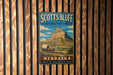 A vintage-style metal sign for the National Monument in Nebraska, featuring a wagon on a trail and a mountain in the background.