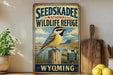 A vintage-style sign for the Seedskadee National Wildlife Refuge in Wyoming, featuring a bird perched on a wooden post against a scenic landscape.