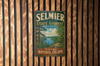 A vintage-style metal sign for Selmier State Forest in Indiana, featuring a scenic landscape with a lake and forest.