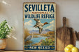 a vintage-style sign for the Seville National Wildlife Refuge in New Mexico, with a painting of a bird in flight and a serene landscape in the background.