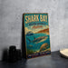 A vintage-style sign for Shark Bay, Western Australia, featuring a shark, a boat, and underwater scenery.