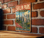 A vintage-style metal sign for Shilin Park, China, featuring a scenic landscape with mountains, a pagoda, and a stone forest.