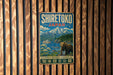 A vintage-style metal sign with the text "SHIRETOKO JAPAN" and an illustration of a bear standing in front of a mountain landscape.