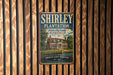 A vintage metal sign for Shirley Plantation, a historic plantation in Virginia, is displayed on a wooden wall.