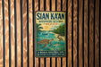 A vintage metal sign for the Si'an Ka'an Biosphere Reserve in Mexico, featuring a tropical landscape with a turtle, palm tree, and other wildlife.
