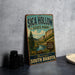 A vintage-style metal sign for Sica Hollow State Park, featuring a scenic landscape with mountains, trees, and a river.