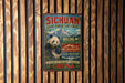 a vintage-style sign for the Giant Panda Sanctuary in Sichuan, China, with a panda bear illustration and text promoting the sanctuary.