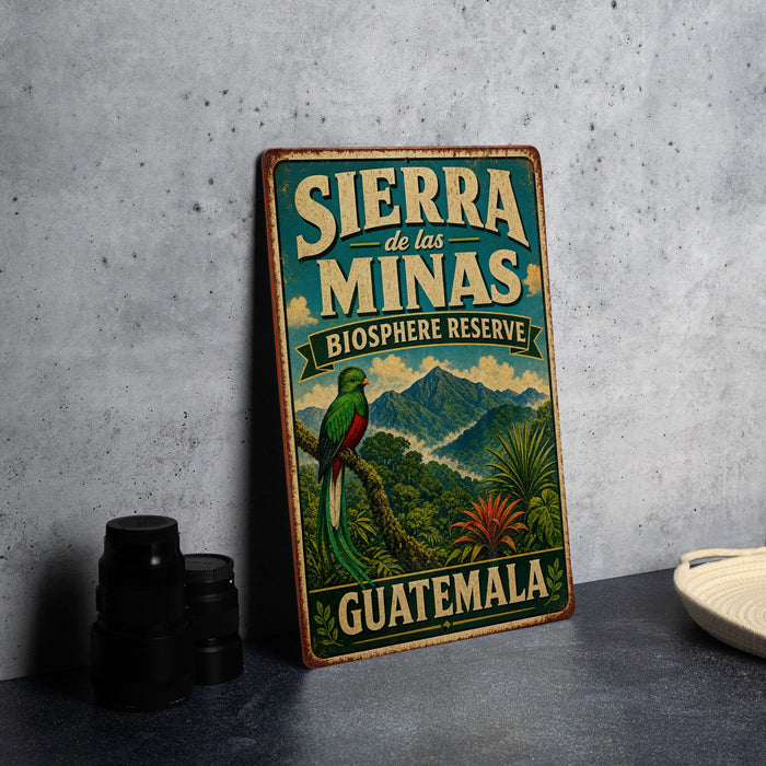 A vintage-style sign for Sierra de las Minas Biosphere Reserve in Guatemala, featuring a colorful illustration of a bird and tropical foliage.