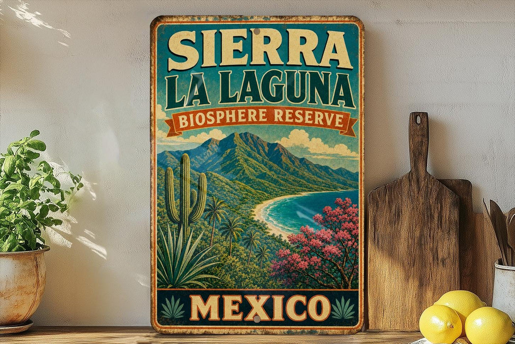 A vintage-style sign for Sierra La Laguna Biosphere Reserve in Mexico, featuring a scenic landscape with mountains, palm trees, and a beach.