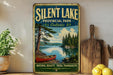 A vintage-style metal sign for Silent Lake Provincial Park in Ontario, featuring a canoe on a lake surrounded by pine trees.