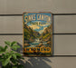 A vintage-style sign for Sinks Canyon State Park in Wyoming, featuring a scenic illustration of a river and mountains.