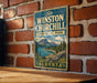 A vintage-style metal sign for Sir Winston Churchill Provincial Park in Alberta, Canada, featuring a scenic mountain landscape.