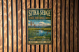 A vintage metal sign for Sitka Sedge State Natural Area in Oregon, featuring a scenic landscape with a mountain and a river.