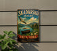 A vintage metal sign with a scenic image of a boat on a lake, surrounded by mountains and a bird in flight, advertising the Skadarsko Jezero.