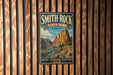 A vintage-style metal sign for Smith Rock State Park in Oregon, featuring a scenic mountain landscape with a river and forest.