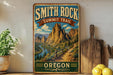 A vintage-style metal sign for the Smith Rock Summit Trail in Oregon, featuring a scenic mountain landscape with a winding trail and lush vegetation.