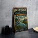 A vintage-style sign for the South Slough National Estuarine Research Reserve in Oregon, featuring a large blue heron in a grassy field with a river and a building in the background.