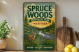 a vintage-style metal sign for the Province Park in Manitoba, Canada, with a scenic illustration of a deer in the foreground and a river in the background. The sign also includes the words "Spruce Woods" and "PRIVATE PARK MANITOBAN".