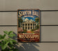 A vintage metal sign for Stanton Hall in Mississippi, featuring a large illustration of the historic building surrounded by trees and flowers.