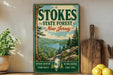 a vintage-style sign for Stokes State Forest in New Jersey, with a scenic landscape of mountains, trees, and a lake. The sign is displayed on a wooden shelf, surrounded by various kitchen utensils and a potted plant.