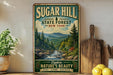 A vintage-style sign for Sugar Hill State Forest in New York, featuring a scenic mountain landscape with a river and pine trees.