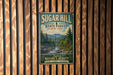 A vintage-style metal sign for Sugar Hill State Forest in New York, featuring a scenic mountain landscape and inviting visitors to explore nature's beauty.