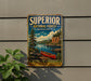 A vintage metal sign advertising the Superior National Forest in Minnesota, featuring a canoe on a river surrounded by pine trees and mountains.