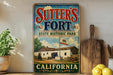 a vintage-style sign for Sutter's Fort State Historic Park in California, with a wooden paddle and a potted plant in the foreground.