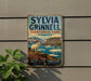 A vintage metal sign for Sylvia Grinnell Territorial Park, featuring a white ram standing on a rocky cliff overlooking a body of water.