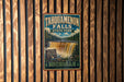 A vintage-style metal sign for Tahquamenon Falls State Park in Michigan, featuring a waterfall and forest scenery.