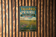 A vintage-style metal sign for Tallgrass Prairie, Kansas, featuring a pastoral landscape with flowers and grass.