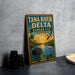 A vintage-style metal sign for the Tana River Delta in Kenya, featuring an illustration of a hippopotamus, flamingo, and other wildlife in a scenic landscape.