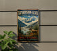 A vintage-style metal sign with a scenic mountain landscape and a reindeer, advertising Tatshenshini-Alsek Provincial Park in British Columbia, Canada.