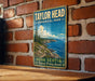 A vintage-style metal sign for Taylor Head Provincial Park in Nova Scotia, featuring a scenic coastal landscape with pine trees and a rocky coastline.