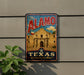 A vintage-style sign for "The Alamo" in Texas, featuring a large image of the historic Alamo building and the text "Remember the Alamo!"