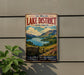 A vintage metal sign advertising the Lake District, United Kingdom, featuring a scenic landscape with mountains, a lake, and a wooden fence.
