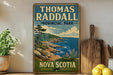 A vintage-style sign for Thomas Radcliffe Provincial Park in Nova Scotia, featuring a scenic coastal landscape with rocky cliffs, pine trees, and a body of water.