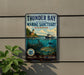 A vintage-style sign for Thunder Bay National Marine Sanctuary, Michigan, featuring a lighthouse, a ship, and underwater scenery.