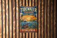 A vintage metal sign for Tidewater Virginia, featuring a sailboat, crane, and a sunset over the water, mounted on a wooden wall.