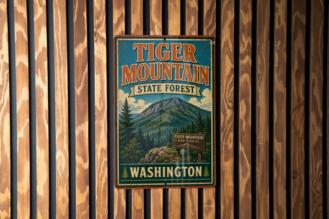 A vintage metal sign for Tiger Mountain State Forest in Washington, featuring a mountain landscape and the text "Tiger Mountain State Forest Washington".
