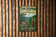 A vintage metal sign for Tom Dorman State Nature Preserve in Kentucky, featuring a scenic illustration of a forest and a red cardinal bird.
